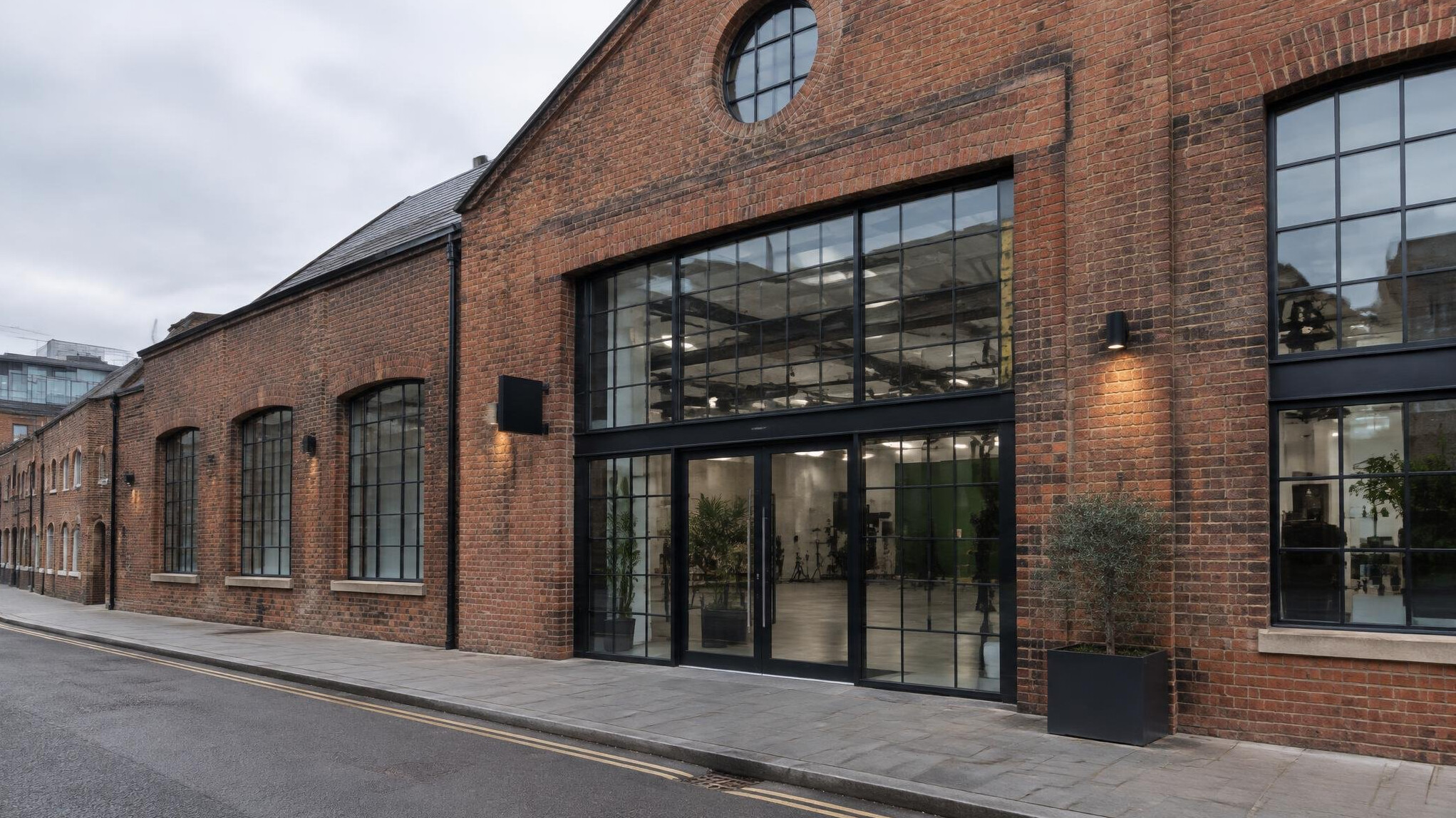 Modern brick building in London with large glass entrance used as a media studio