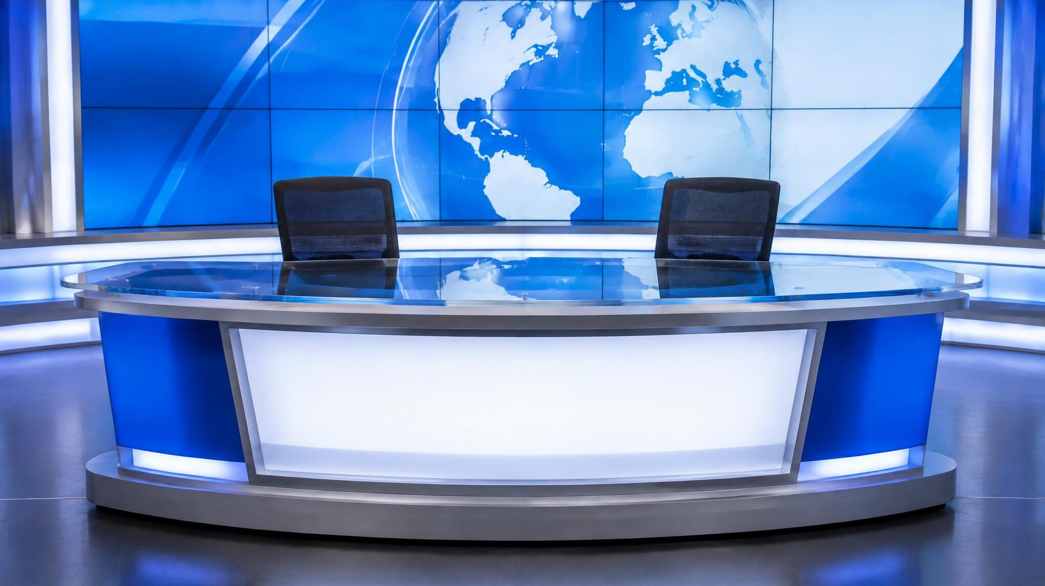 Empty news desk set with illuminated backdrop in a television studio